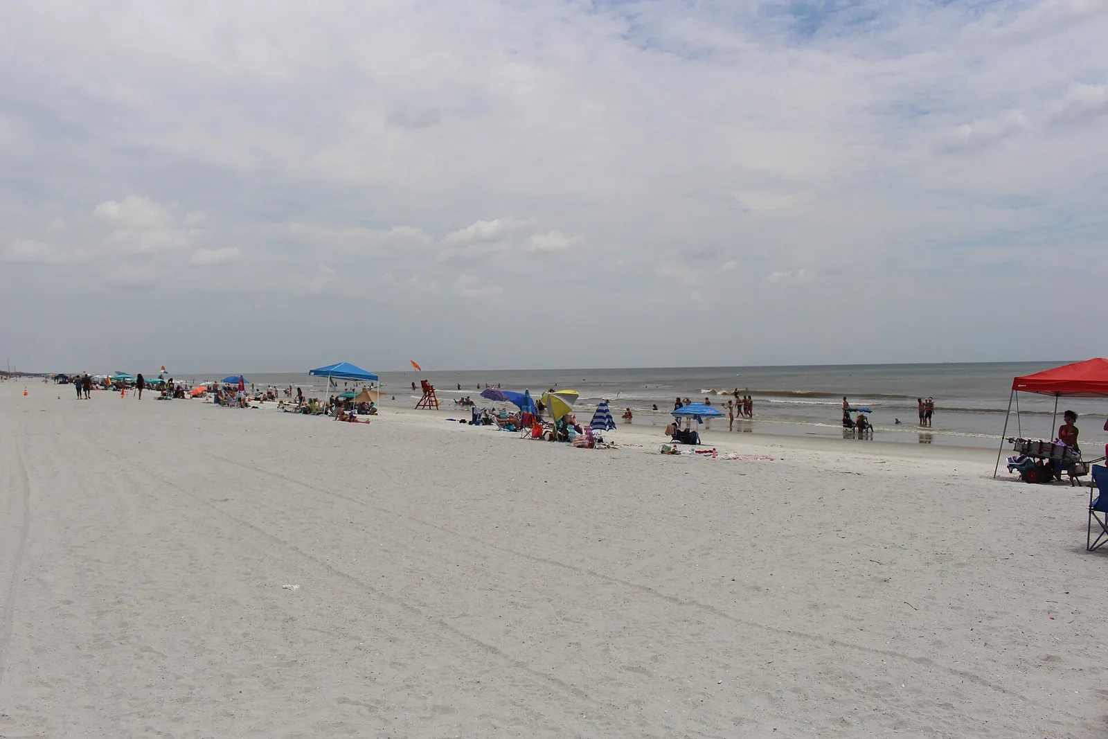 Beachgoers and umbrellas along the shoreline at Neptune Beach, Florida