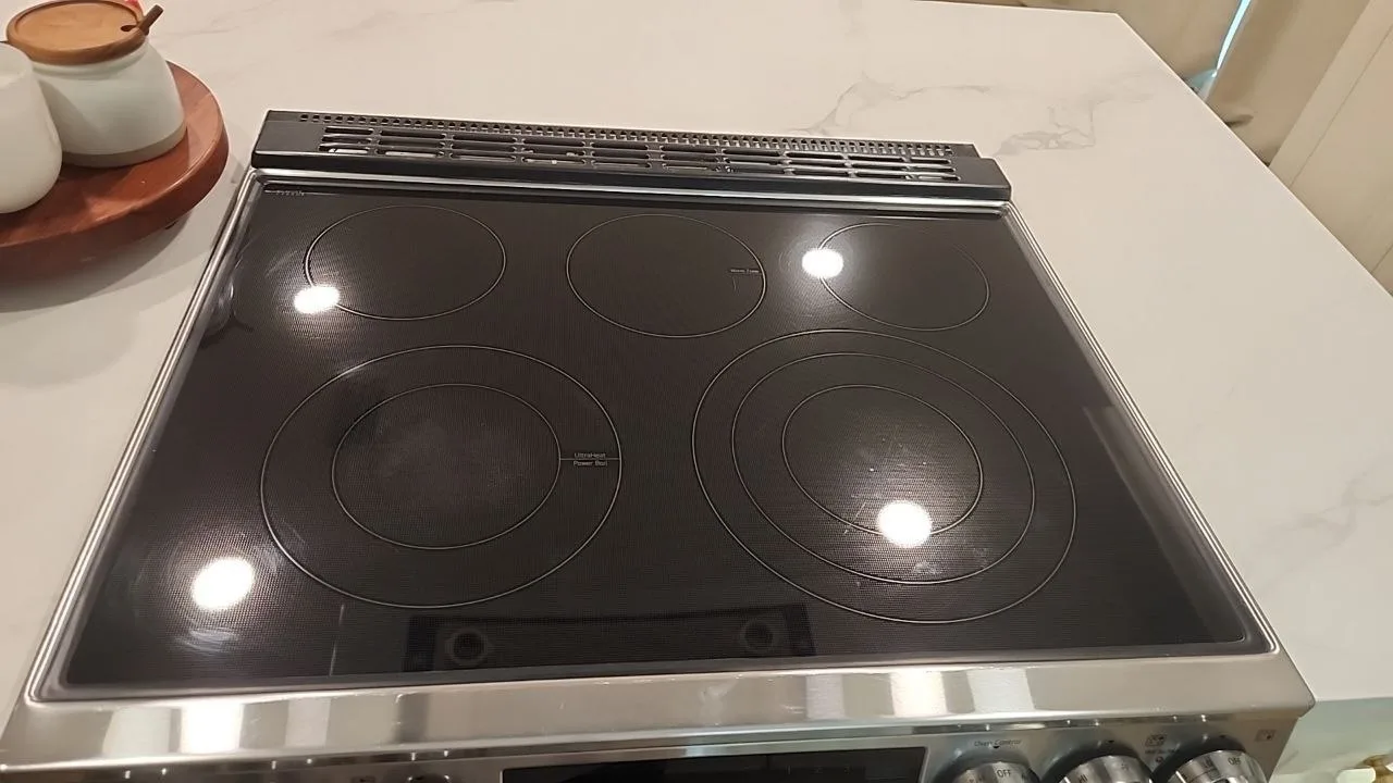Clean black cooktop with burner markings and overhead light reflections