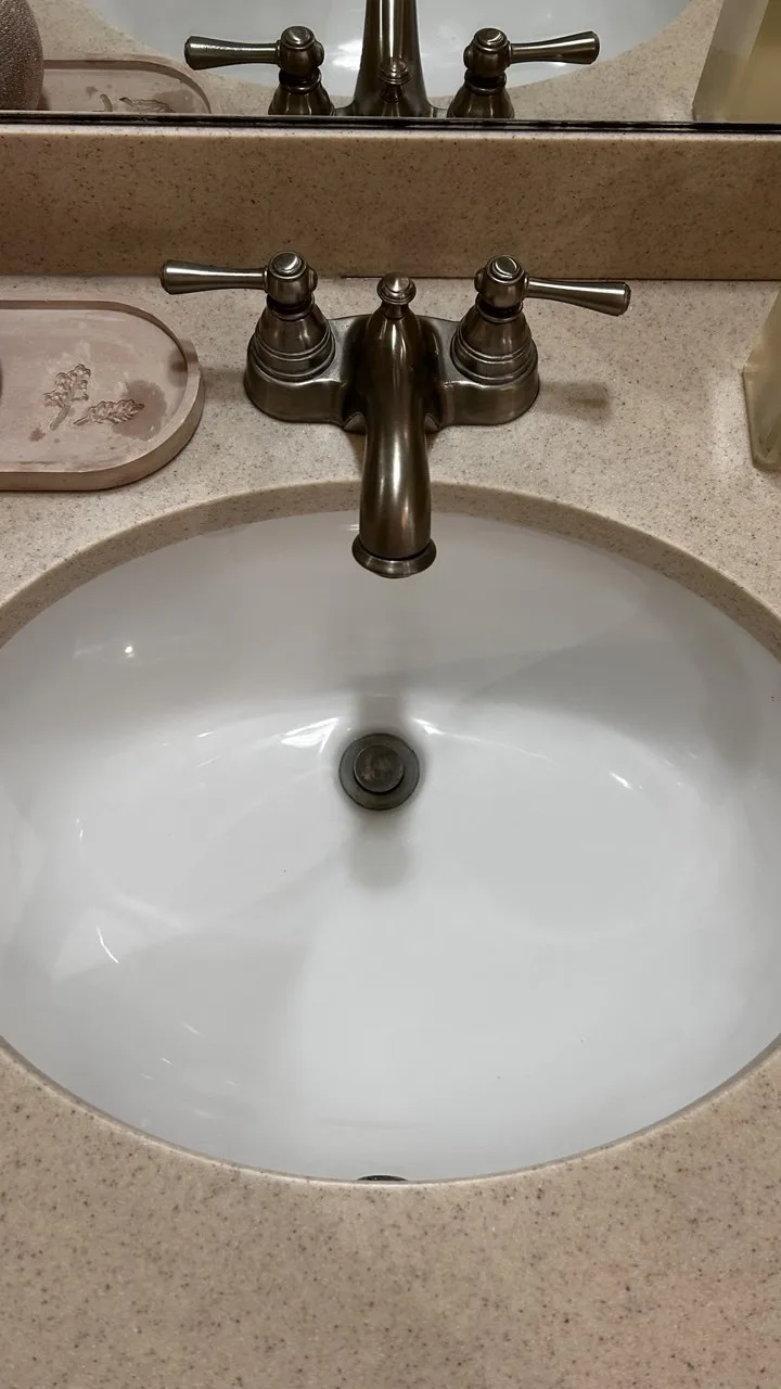 Oval bathroom sink and bronze faucet after cleaning