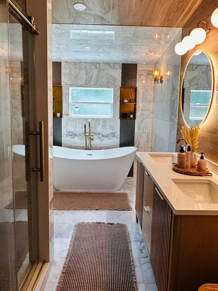 Freshly finished bathroom with a freestanding tub, marble tile and a double vanity