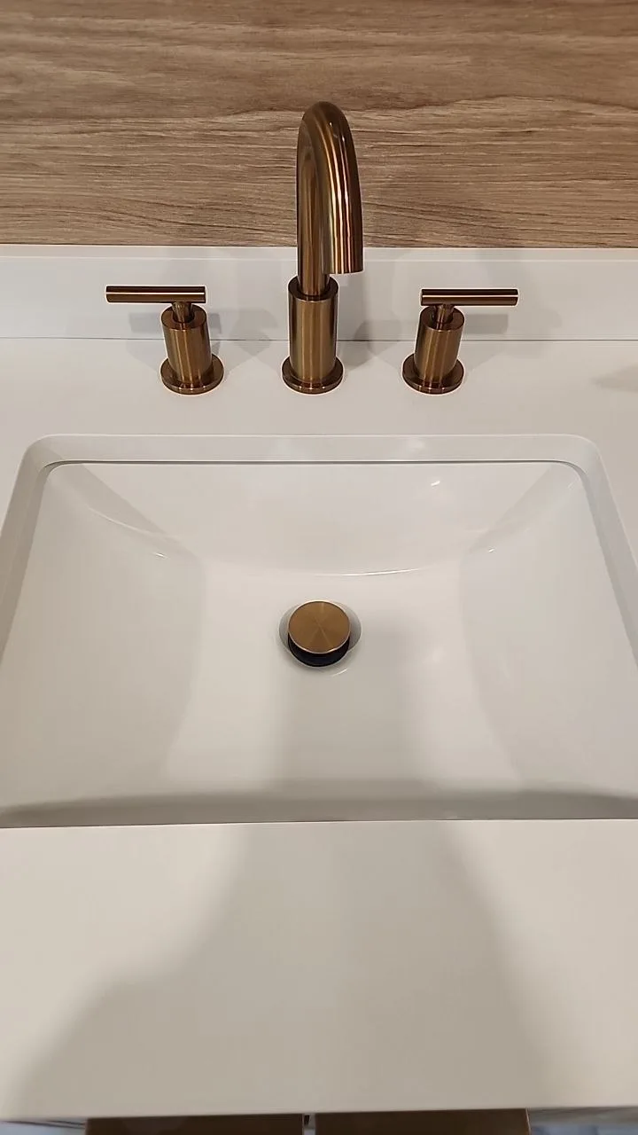 White rectangular sink and bronze fixtures after cleaning