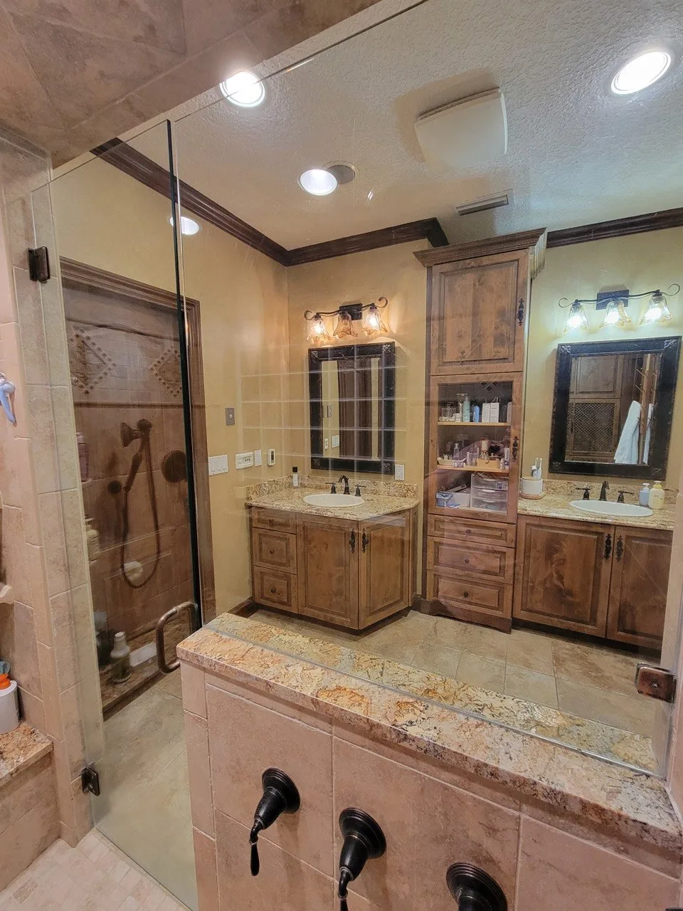 Wooden bathroom vanity visible through the shower glass after cleaning