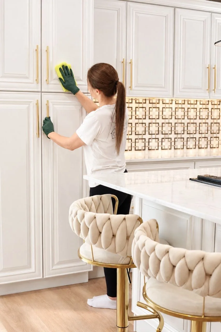 EcoHome cleaner wiping a white kitchen cabinet